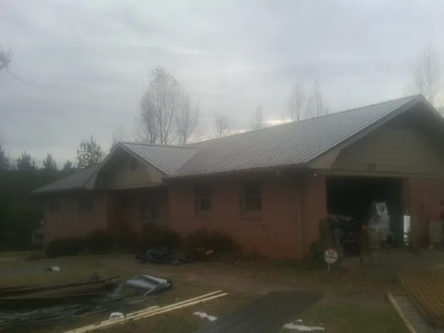 Gray metal roof on a stucco house with an attached garage in Boston